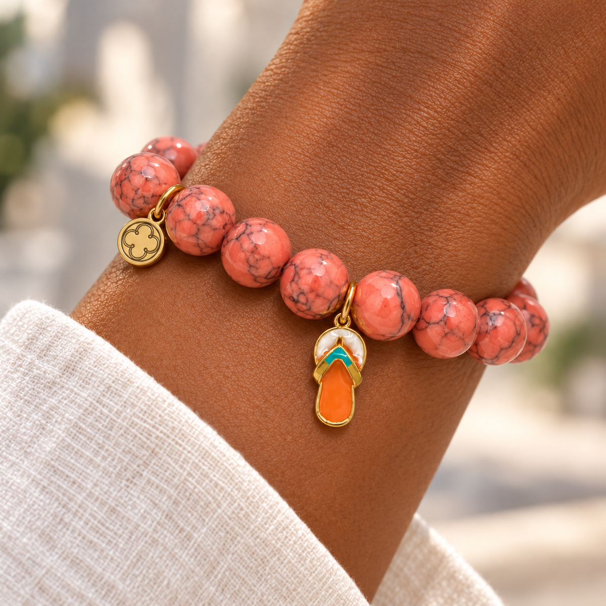 Coral Pink Howlite with Flip Flop Pendant on a woman’s wrist